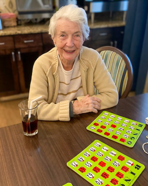 Jodie sitting at a table with BINGO cards in front of her.