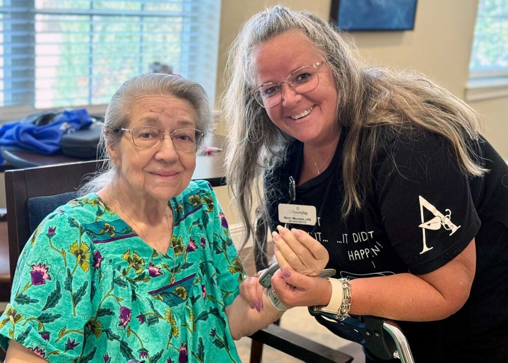 A team member assists a resident with a health check at The Township.