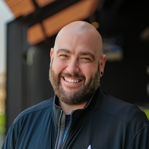 Michael Allen, Culinary Director at The Township Senior Living, smiling in a professional headshot, wearing a black zip-up jacket, with a softly blurred outdoor background.
