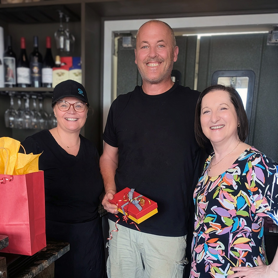 Local businesses owners smile brightly with gifts given by The Township Senior Living.