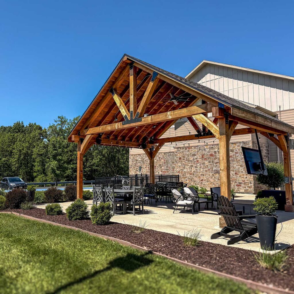 A large, beautiful rustic covered sitting area at The Township, surrounded by planters and landscaping.